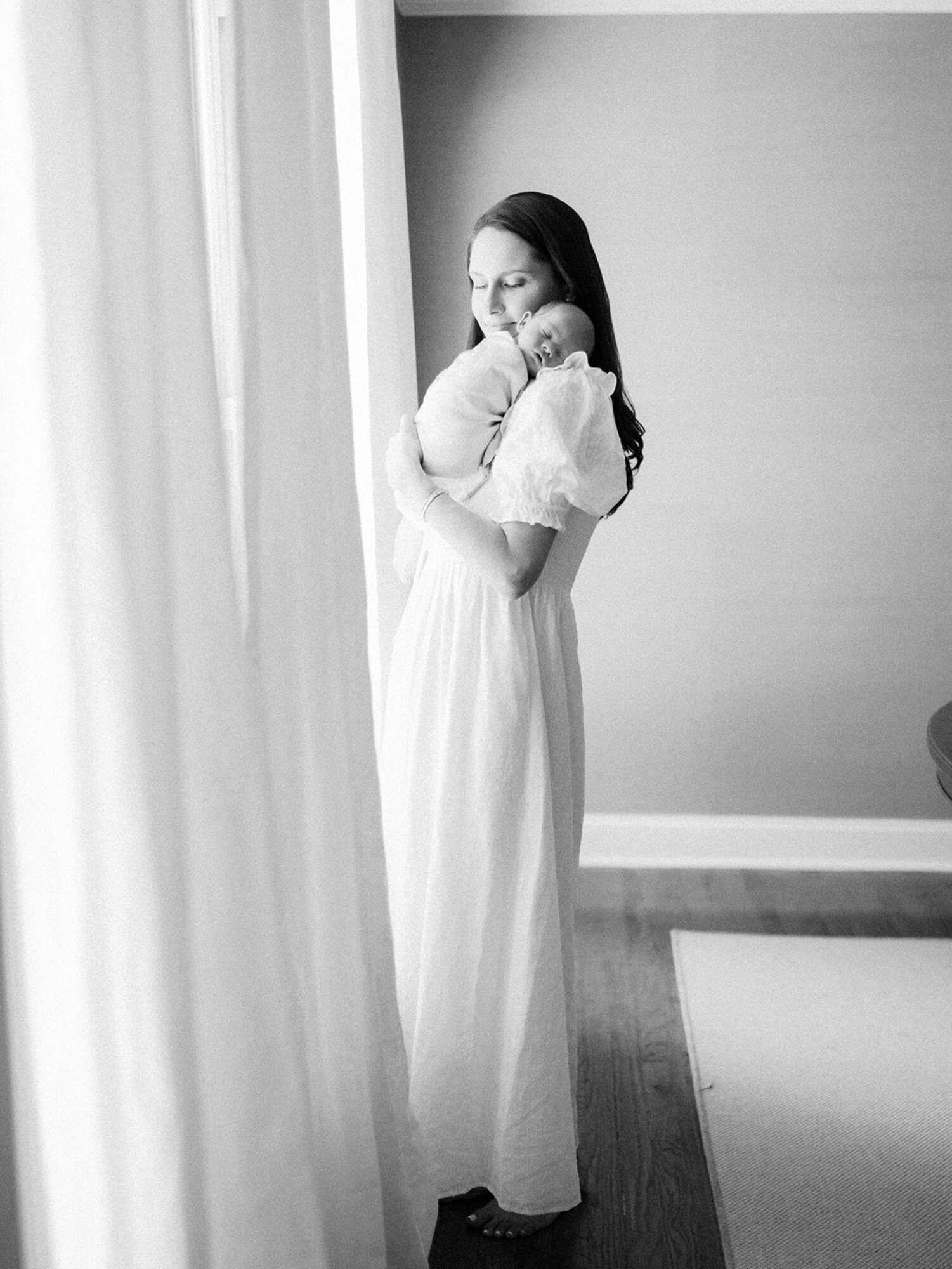 Black and white image of mother holding newborn baby in Dallas Texas