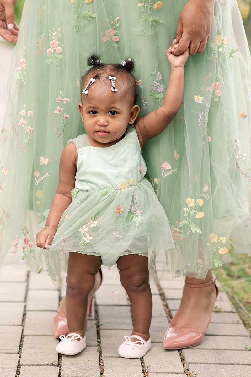 Close up of toddler girl wearing green dress by Maryland Family Photographer