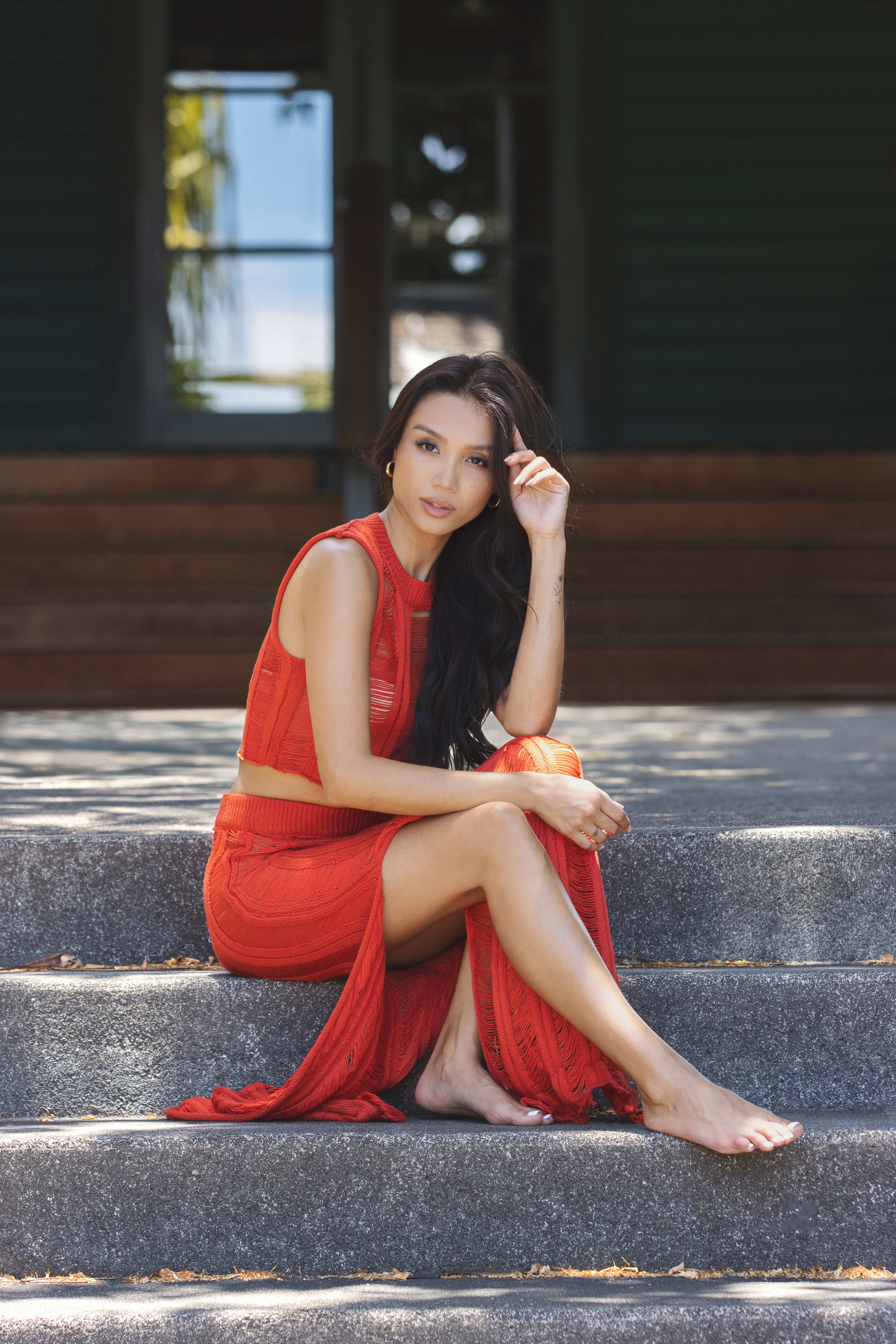 Fashion model in a red dress posing for an editorial-style shoot in Maui