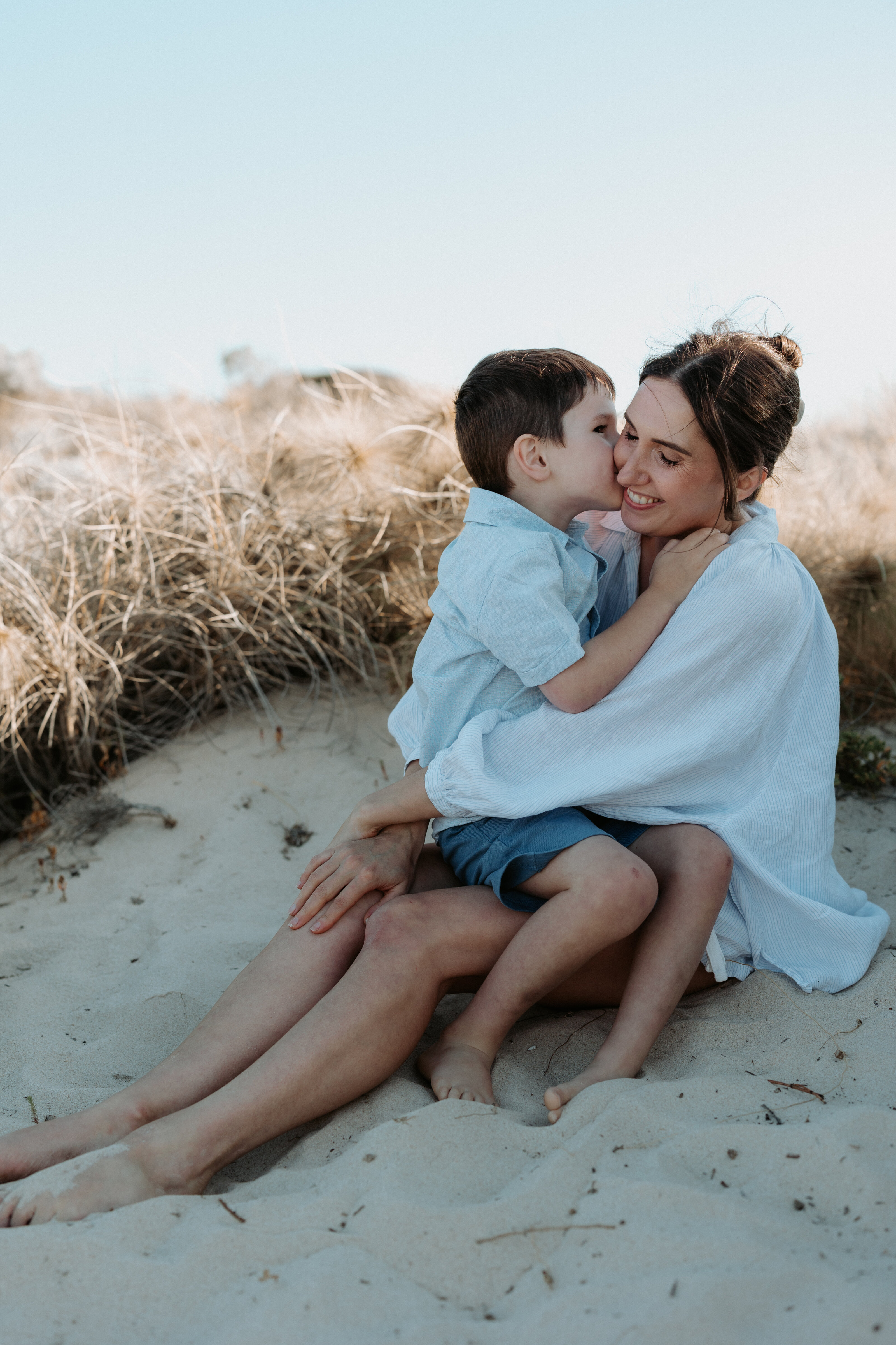 Family sharing a loving hug in a natural, relaxed setting in Perth
