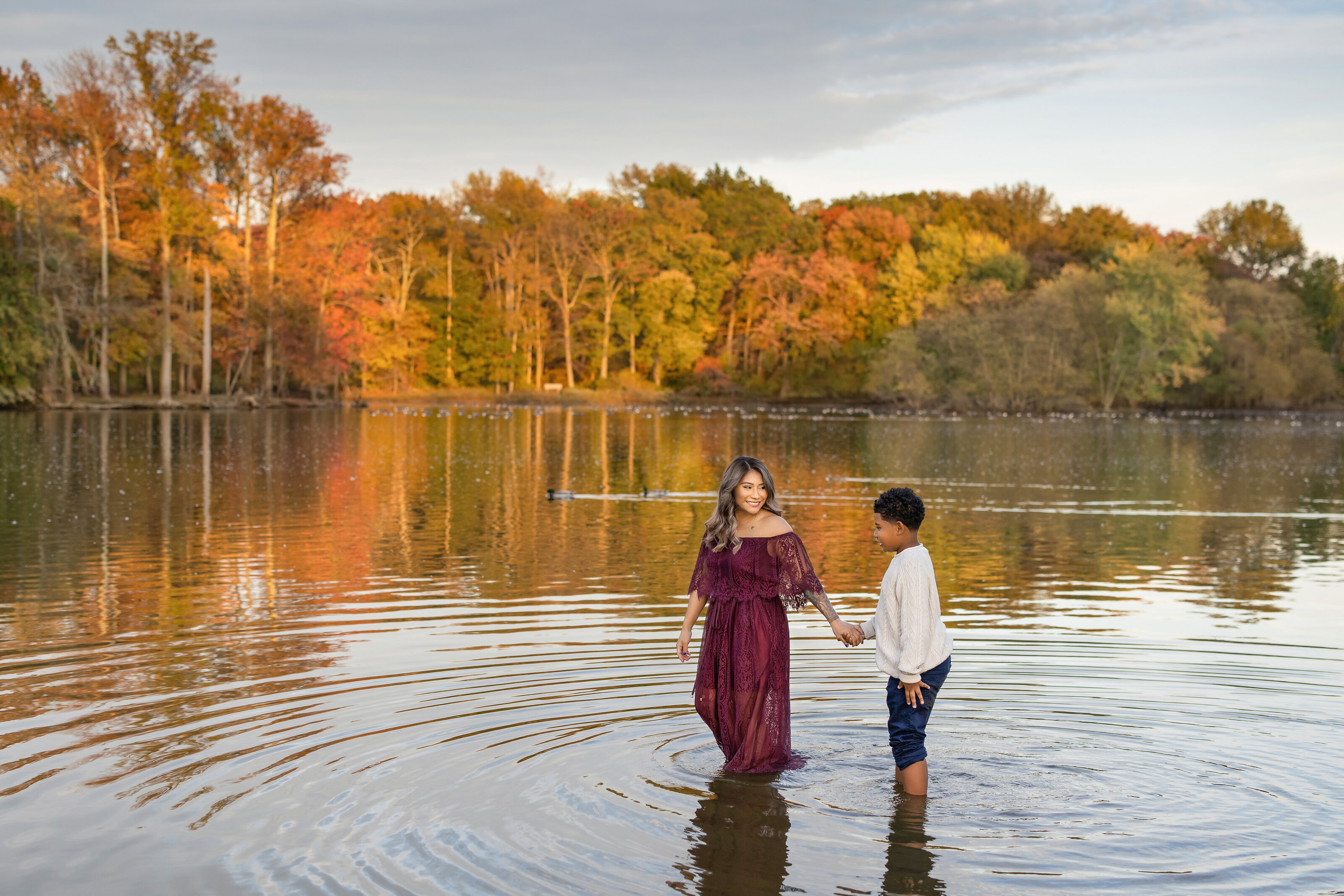 mother and child walk through Veterans Park lake during family photography session in New Jersey