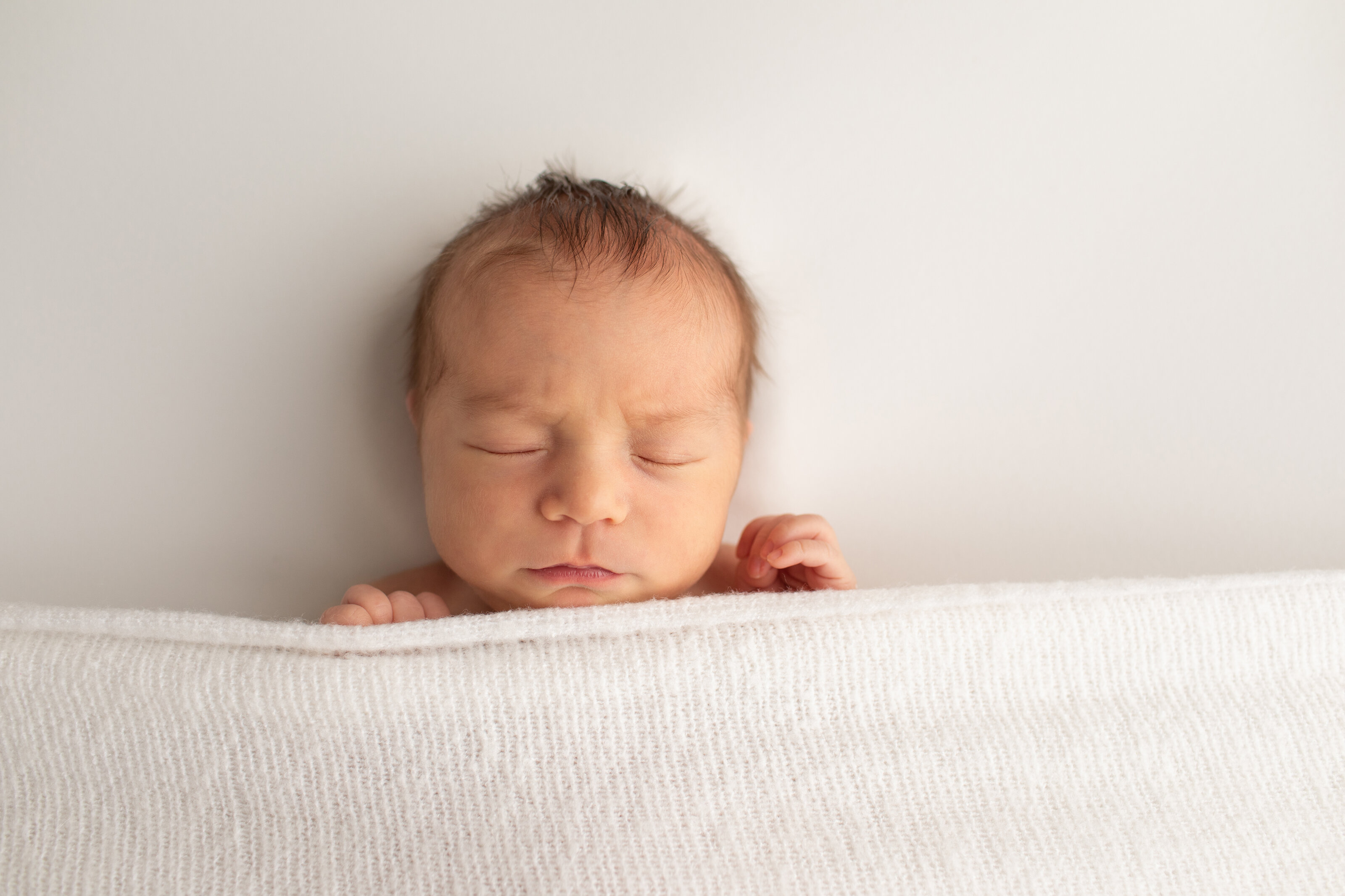 Sleeping baby boy with blanket covering him for newborn photography columbia md session