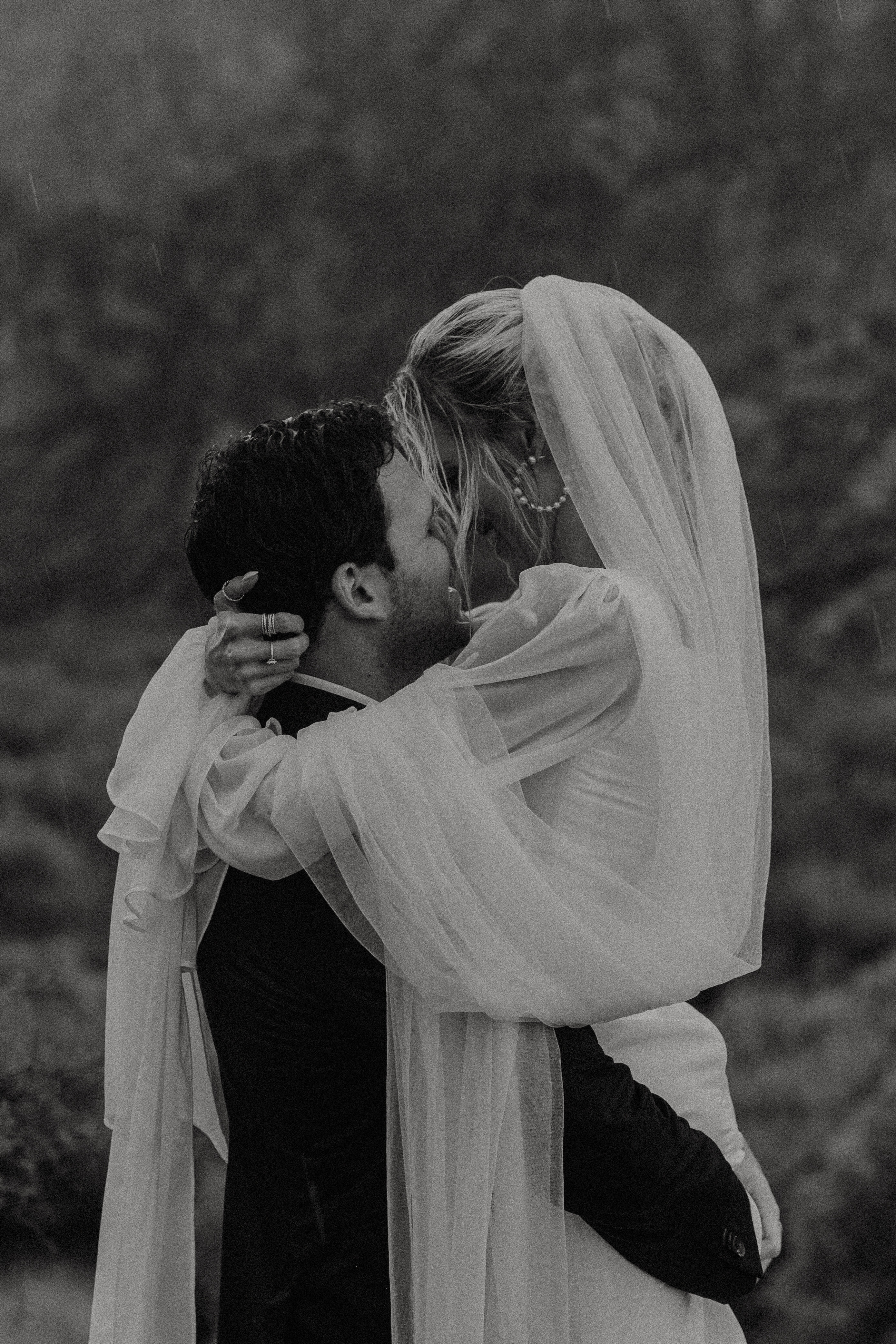 black and white photo of a couple standing in the rain and kissing like the charactes in the notebook movie