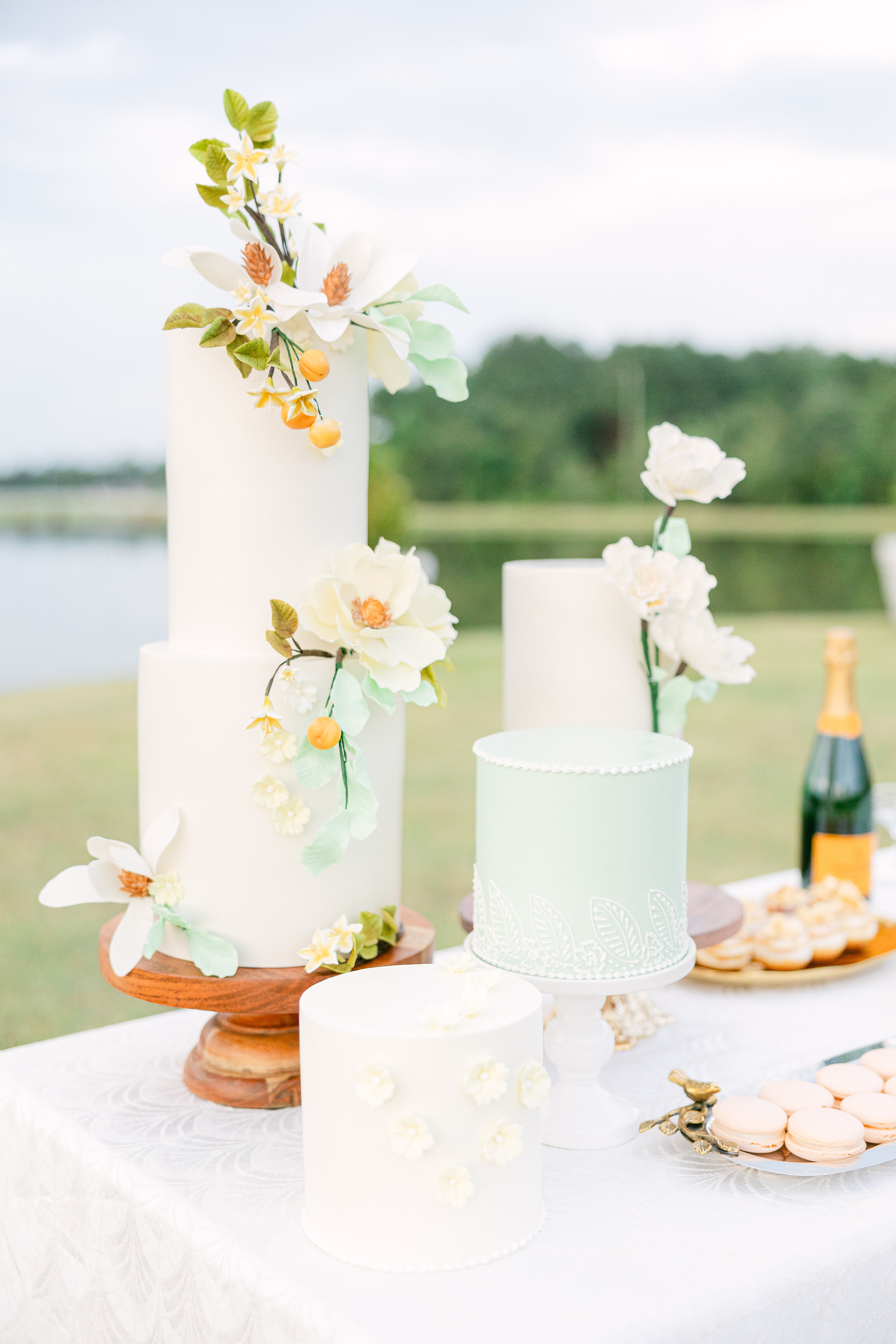 A stunning display of handcrafted wedding cakes adorned with delicate sugar flowers at a luxury Savannah wedding. Designed by D'FlavorCC for an elegant celebration.