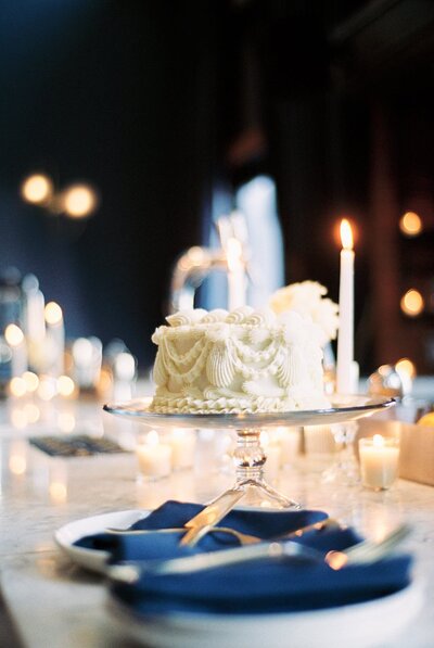 minimalistic white wedding cake on table with candles