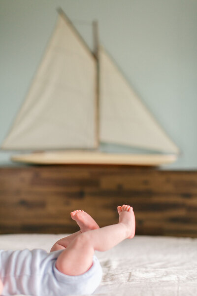 Coeur d'Alene photographer captures new parents admiring newborn baby in natural light lifestyle portrait by window