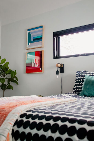 Room with white walls and white carpet, orange velvet chair, floating shelf and boho wall hanging