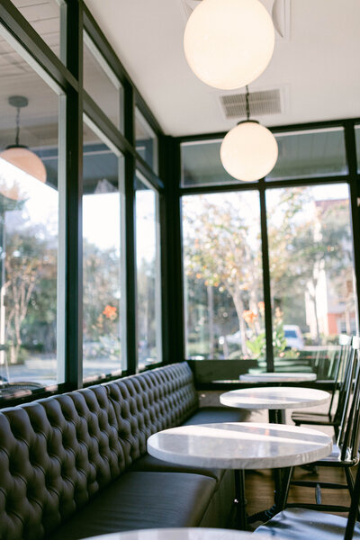 Glass window with black seats and white tables