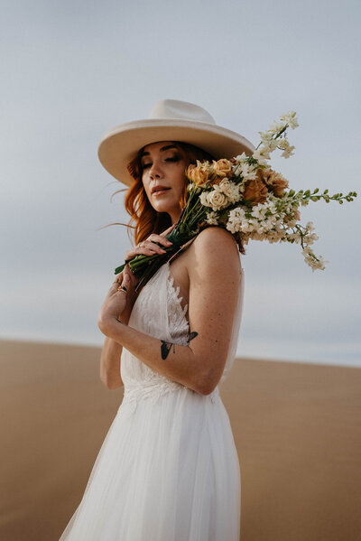 bride with hat and bouquet