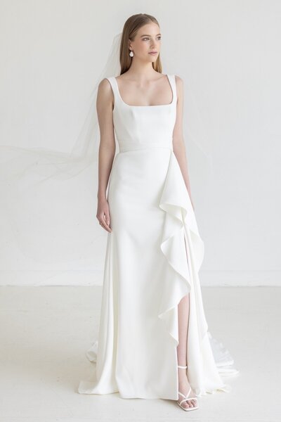 bride in a simple scoop-neck gown with ruffle detail on the skirt.
