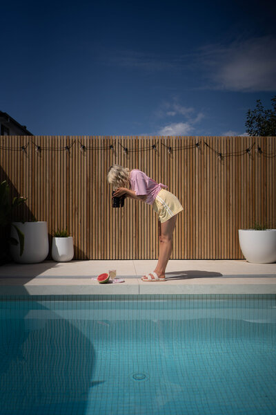 Jessie from The Film Room is taking footage by a swimming pool 