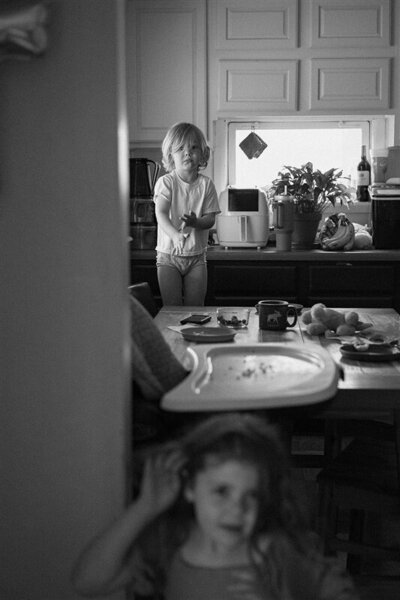 Black and white photo of kids in messy kitchen