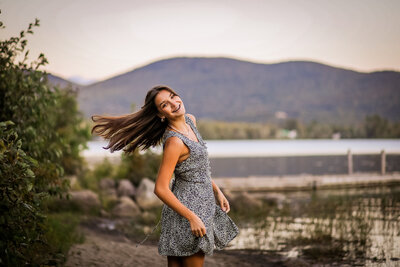 Senior with hair in the wind and mountains in the background | Maine Portrait Photographer