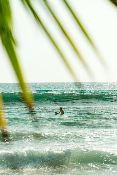 Man sitting on surfboard in the ocean