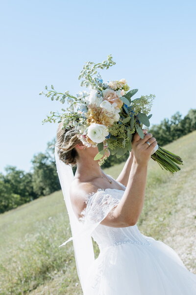 Bride with flower bouquet exiting outdoor ceremony site at Willstone Acres wedding venue