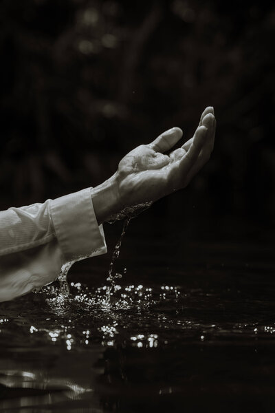 black and white photo of  a mans hand coming out of water