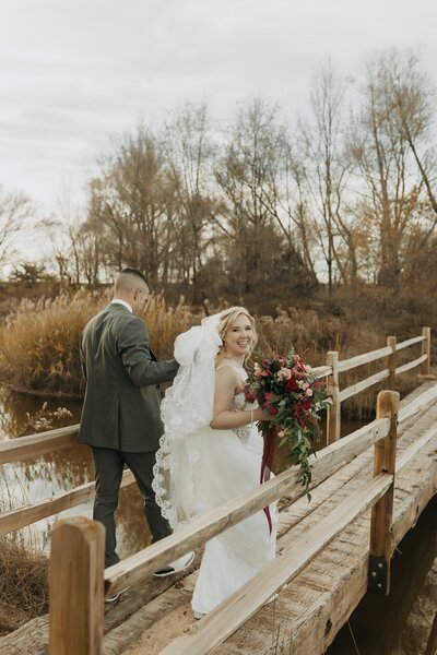 bride and groom crossing bridge
