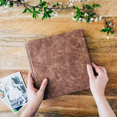 Brown leather wedding album and hands