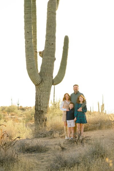 family standing near a cactus smiling