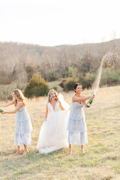 bride and bridesmaids popping champagne