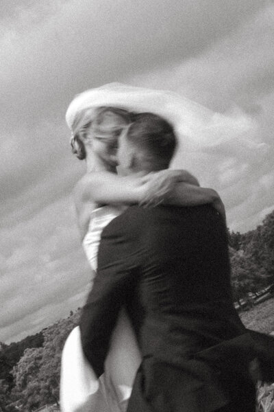 Man and woman romantically spin around, laughing in the middle of a  flowery field