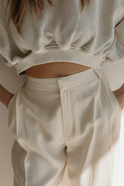 A woman wearing beige clothes and showing her abdomen. Representing the growth that can be fostered in body image therapy in Brooklyn, NY. Where a body image therapist can teach you to embrace all of yourself.