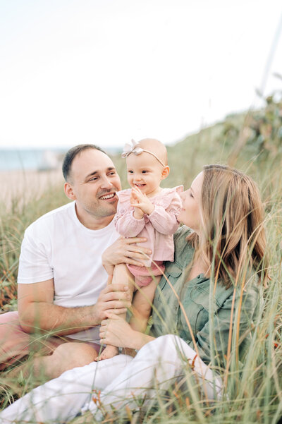 South Florida Family Photographer captures family sitting on grass at the beach