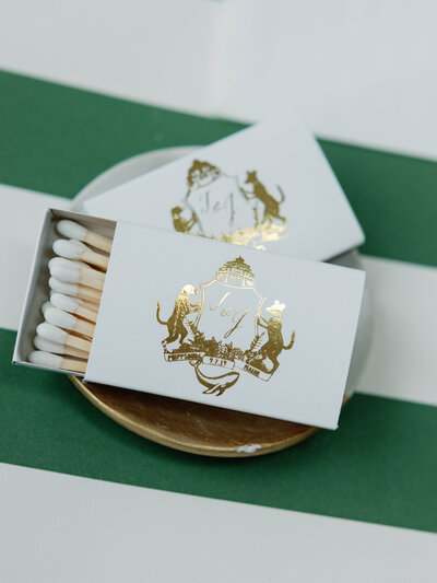 White match stick box featuring gold foil custom monogram crest