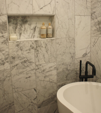 Detailed shot of a tiled shower with inlet for products.