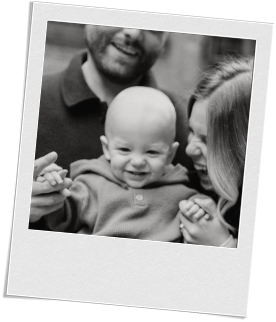 A baby and their parents posing for a smiley photo