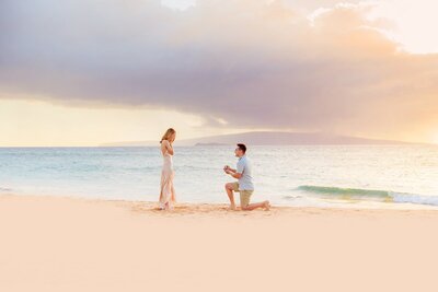 Man proposing to girlfriend on Maui at sunset on the beach with Love + Water
