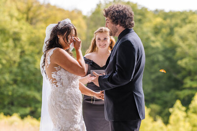 Bride wipes her eyes during ceremony