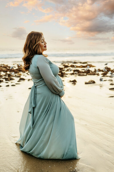 mother and father holding their newborn baby girl during a newborn photo session in orange county