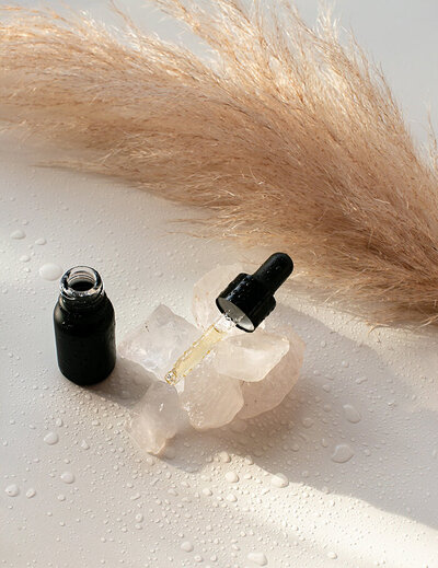 Flacon et pipette posée sur des glaçons pendant la création d'un parfum personnalisé. Pampas en arrière plan.