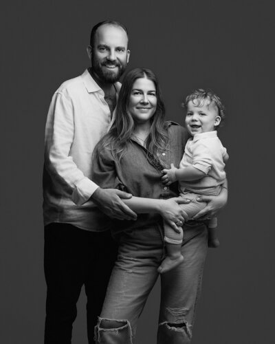 Studio family portrait in Austin, Texas, featuring a happy family of four with warm, candid smiles and soft, elegant lighting, capturing precious moments together.