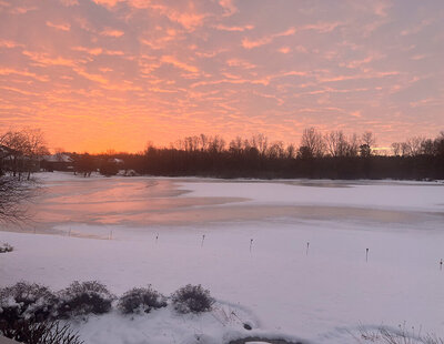 Sunrise over a lake freezing over.