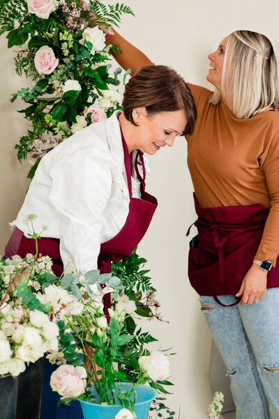 Branding photoshoot of Petal Barn team working on designing an arbor