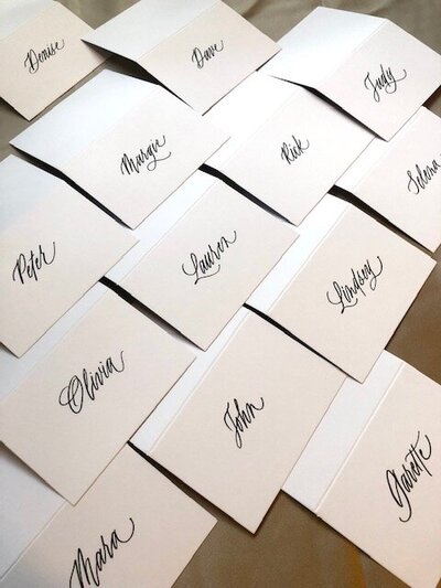 stack of calligraphy envelopes with dried rose on the side