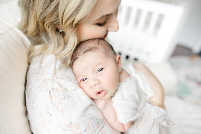 Baby looking at camera snuggled into mom by DC newborn Photographer