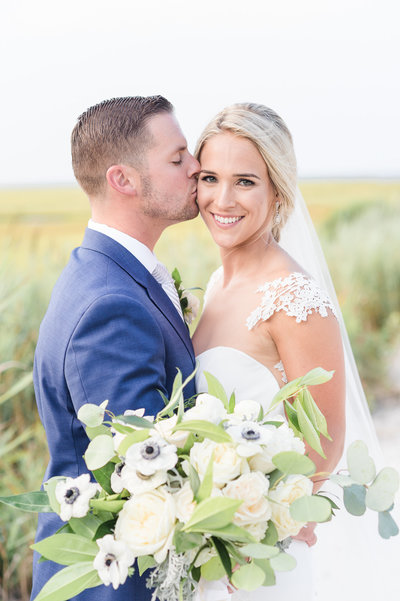 Bride and groom embrace with bouquet at Bonnet Island Estate wedding