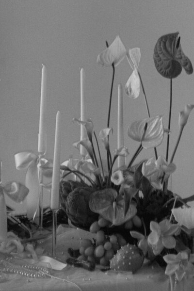 Details of the wedding table with candles, greenery, pearls, pears, magnolias and bows.