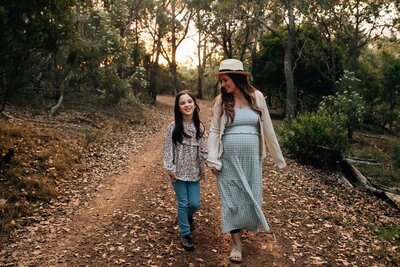 Sunset maternity session, mother and daughter walking down bush lane together.