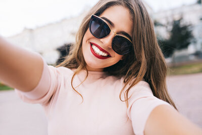 closeup-selfie-portrait-attractive-girl-sunglasses-with-long-hairstyle-snow-white-smile-city