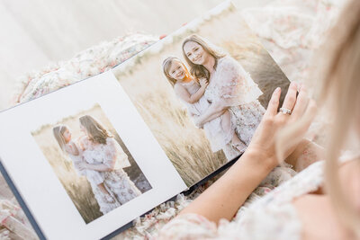 okc mom flipping through her family session album with okc portrait photographer Lacee Smith Photography
