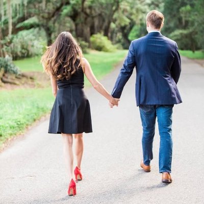 Engaged couple walks down road to the Avenue of Oaks, Magnolia Plantation. Kate captures Charleston wedding photography..