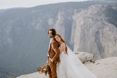 Yosemite elopement couple embrace at taft point overlooking the yosemite valley