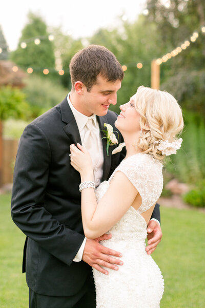 Bride holding a beautiful bouquet of flowers kissing her groom