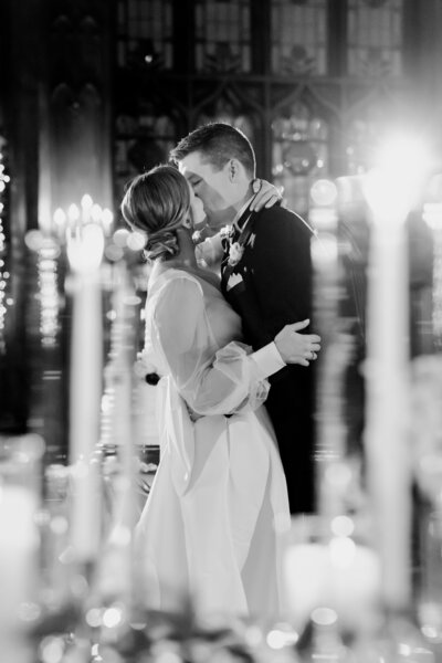 Joyful bride and groom kiss at their candlelight reception at University Club of Chicago