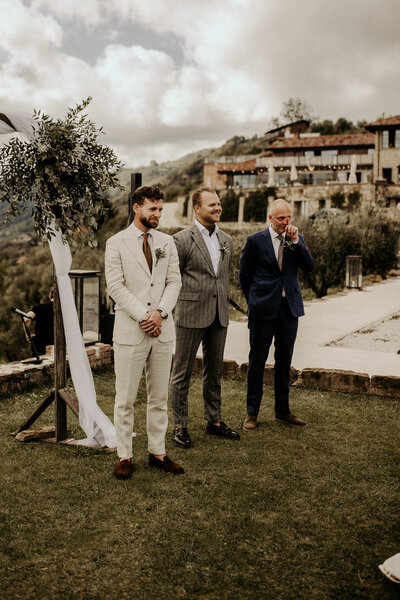 En brudgum och hans pappa gråter när de ser bruden komma gåendes mot dom under en vigsel i Italien