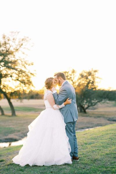 Bride and groom kissing with a sunset at the Vineyard at Florence